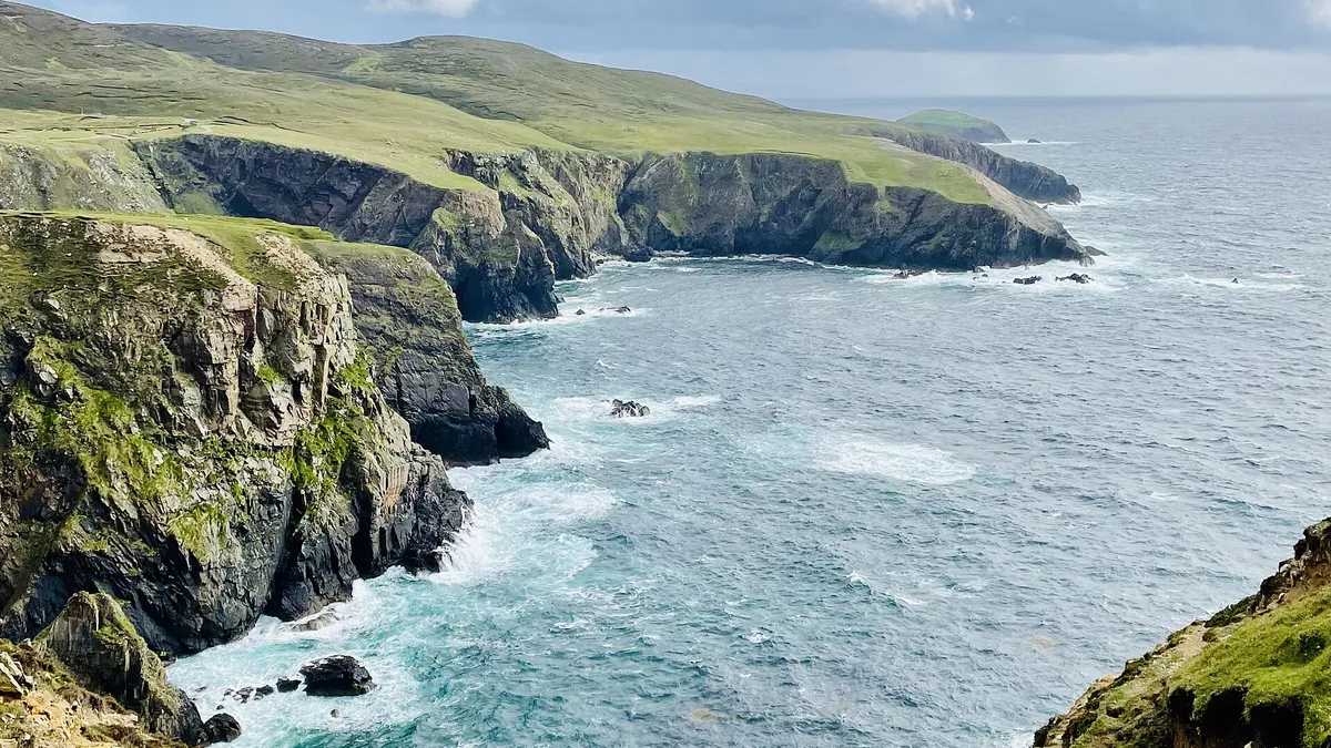 Cliffs and inlets along the shore of Arranmore with Atlantic swell breaking below