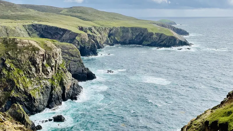 Cliffs and inlets along the shore of Arranmore with Atlantic swell breaking below