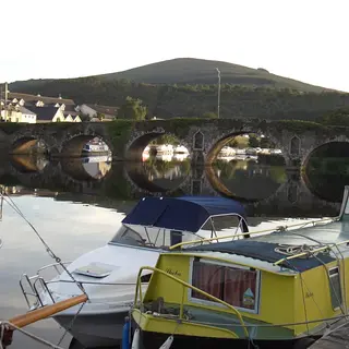 Barges moored on the Barrow below the arched stone bridge at Graiguenamanagh