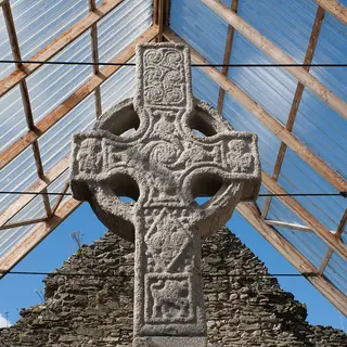 The carved granite head of Moone High Cross under its glass shelter