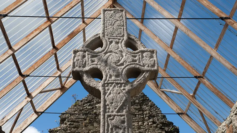 The carved granite head of Moone High Cross under its glass shelter
