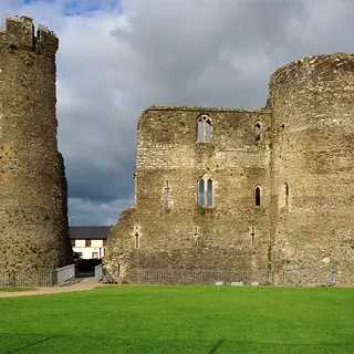 The surviving round tower and wall of Ferns Castle above its lawn