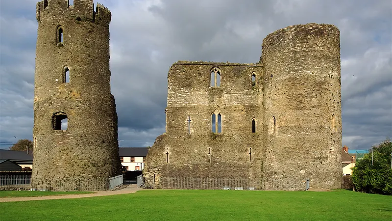 The surviving round tower and wall of Ferns Castle above its lawn