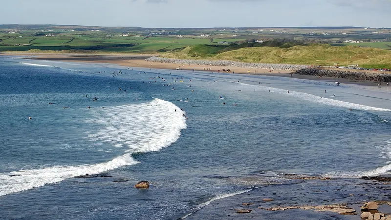 Surf running into the long strand at Lahinch with the dunes behind