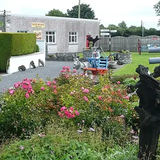 Flower beds and old machinery in the yard outside Derryglad Folk Heritage Museum