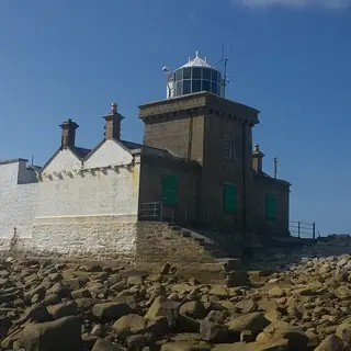 Blacksod Lighthouse and its keeper's houses on the rocks at Blacksod Point
