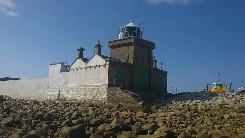 Blacksod Lighthouse and its keeper's houses on the rocks at Blacksod Point