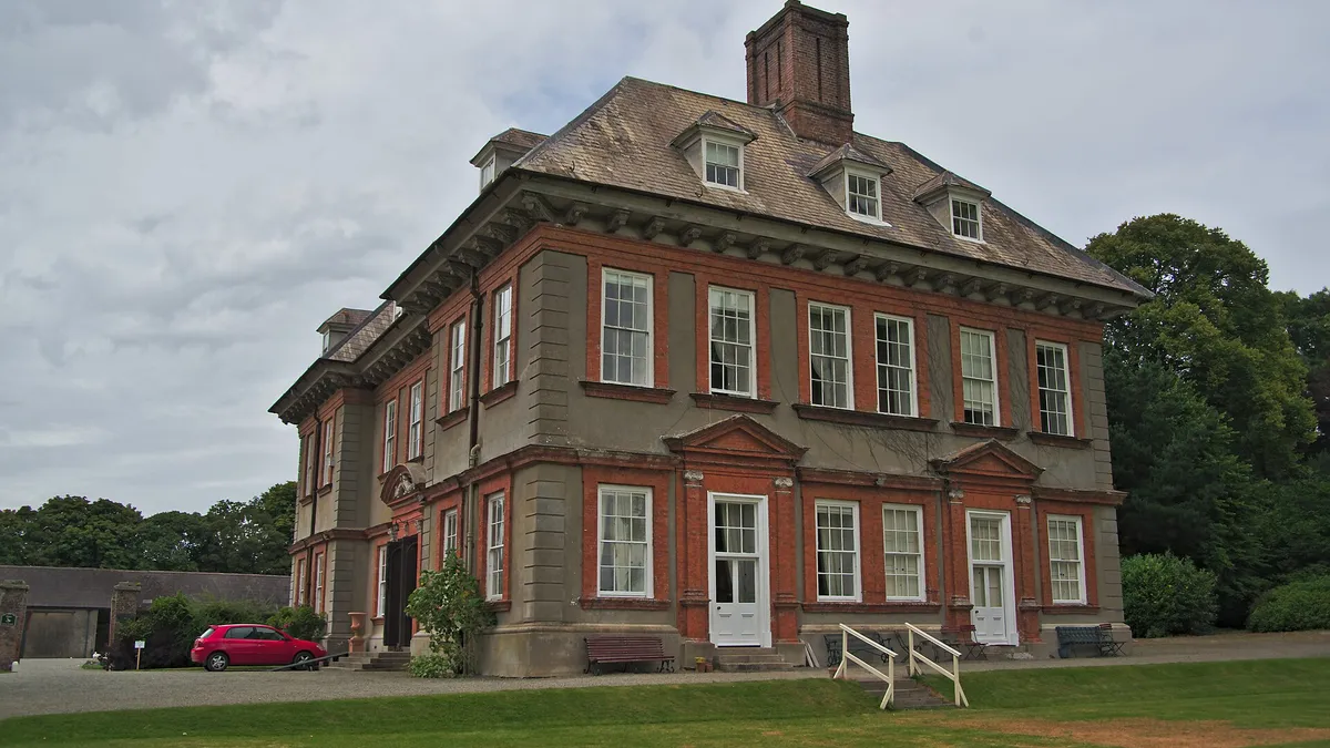 The red brick front of Beaulieu House across its lawn
