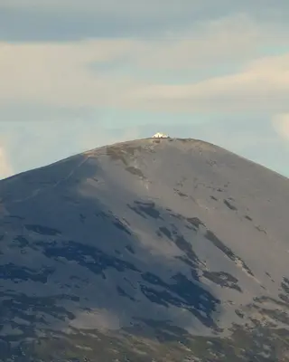 The bare grey cone of Croagh Patrick with the white chapel on its summit