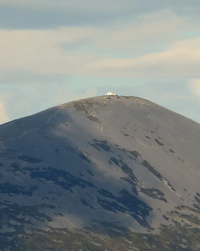 The bare grey cone of Croagh Patrick with the white chapel on its summit