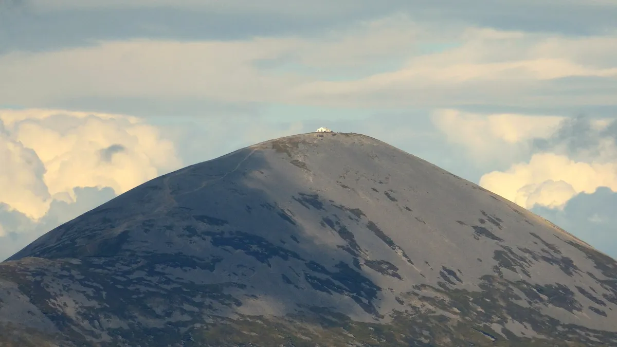 The bare grey cone of Croagh Patrick with the white chapel on its summit