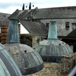 Copper pot stills standing outside the old distillery buildings at Kilbeggan