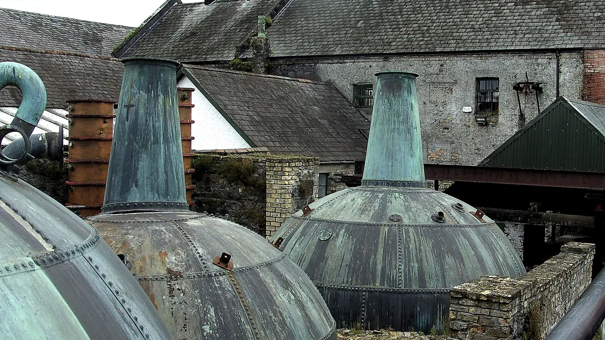 Copper pot stills standing outside the old distillery buildings at Kilbeggan