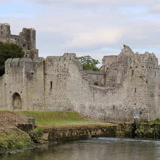 Desmond Castle at Adare with its walls and moat coming down to the river