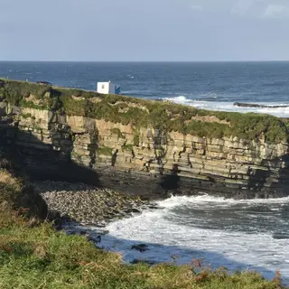 The flat layered cliffs and breaking sea at Mullaghmore Head