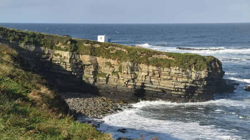 The flat layered cliffs and breaking sea at Mullaghmore Head
