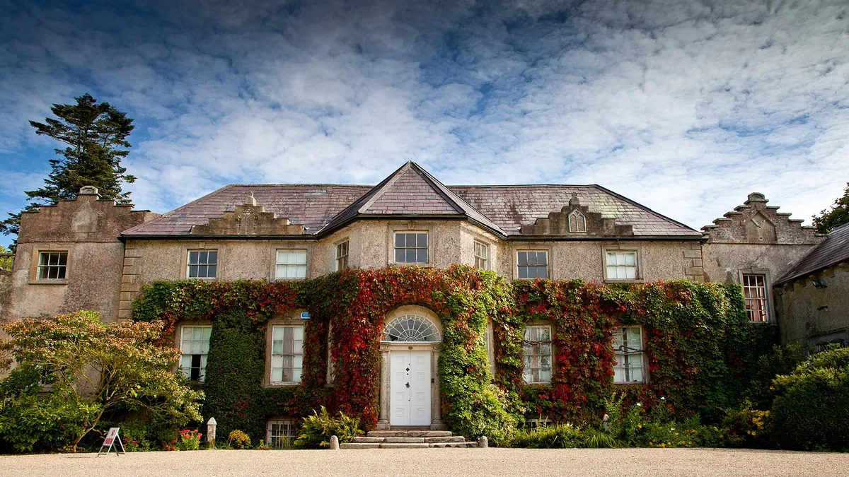 The ivy covered front of the house at Altamont with red creeper across the stonework