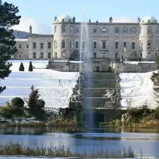 Powerscourt House above its terraced gardens and the fountain lake, with snow on the ground