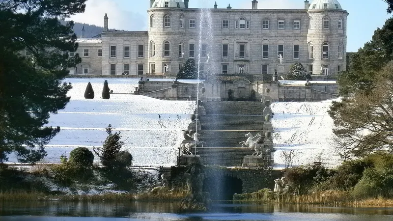 Powerscourt House above its terraced gardens and the fountain lake, with snow on the ground