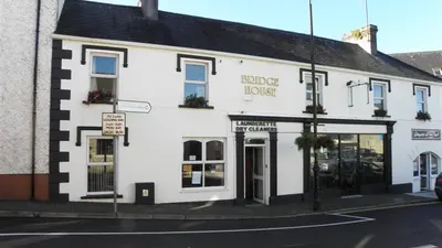 The white painted Bridge House on the street corner in Drumshanbo