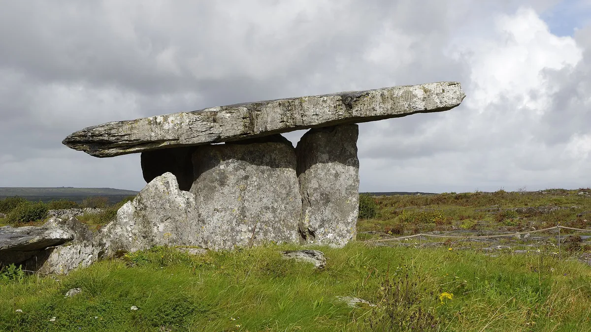 The capstone of Poulnabrone Portal Tomb resting on its uprights out on the Burren limestone