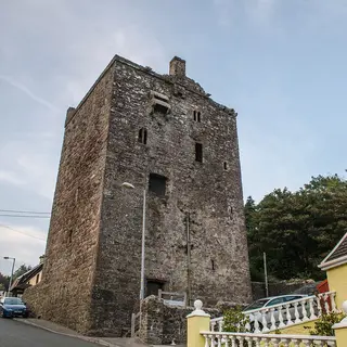 The tall tower house of Ballyhack Castle above the harbour road