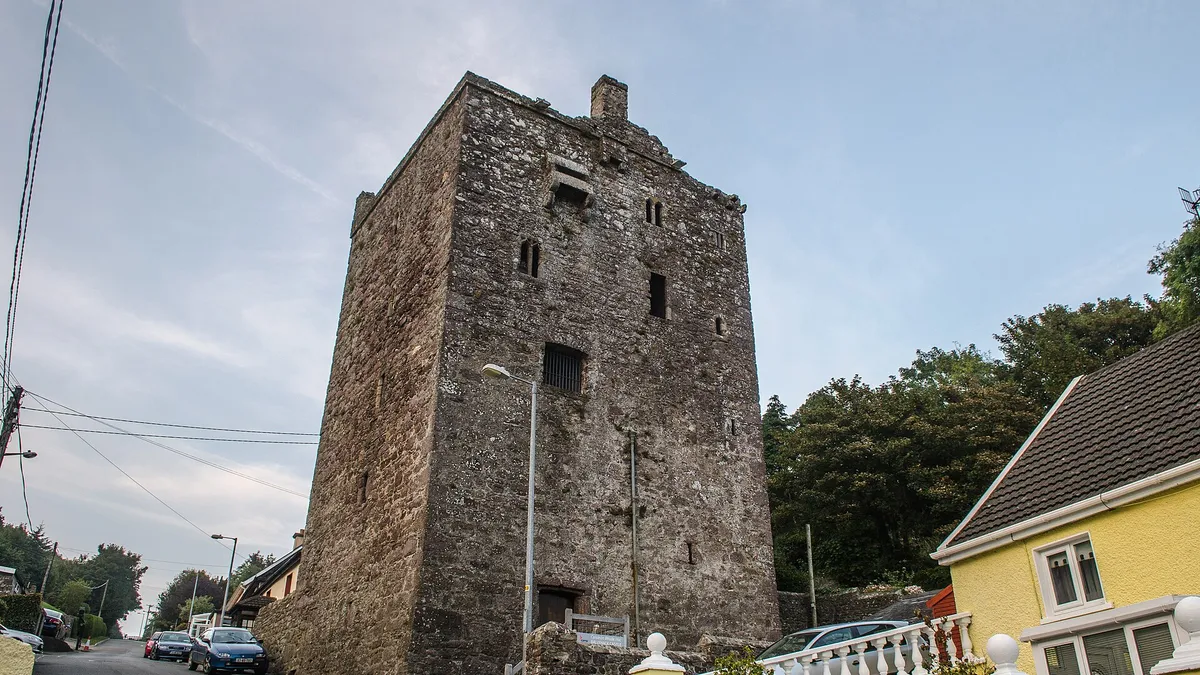 The tall tower house of Ballyhack Castle above the harbour road