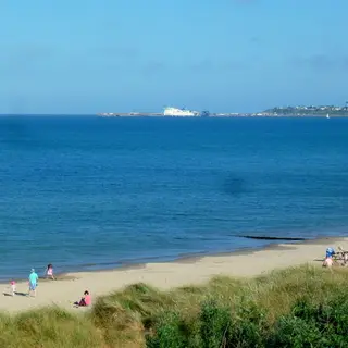 The beach at Rosslare Strand with a ferry on the horizon