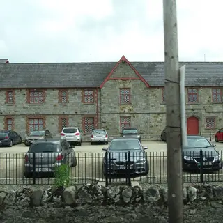 The long two storey stone front of Carrickmacross Workhouse behind its railings