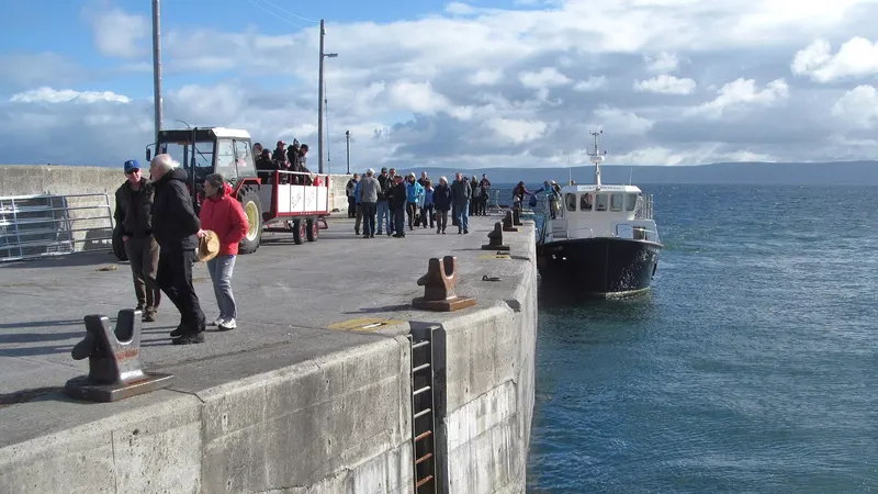 Passengers walking along the pier as the ferry comes in to Inis Oirr