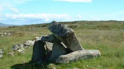 The capstone of Kilclooney Dolmen tilted on its uprights in open bogland