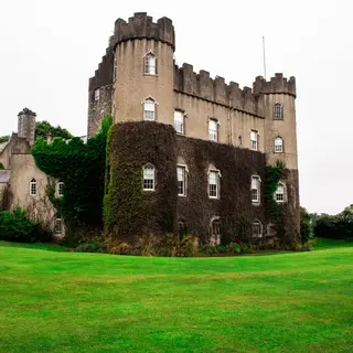 Malahide Castle behind its lawns with ivy on the walls