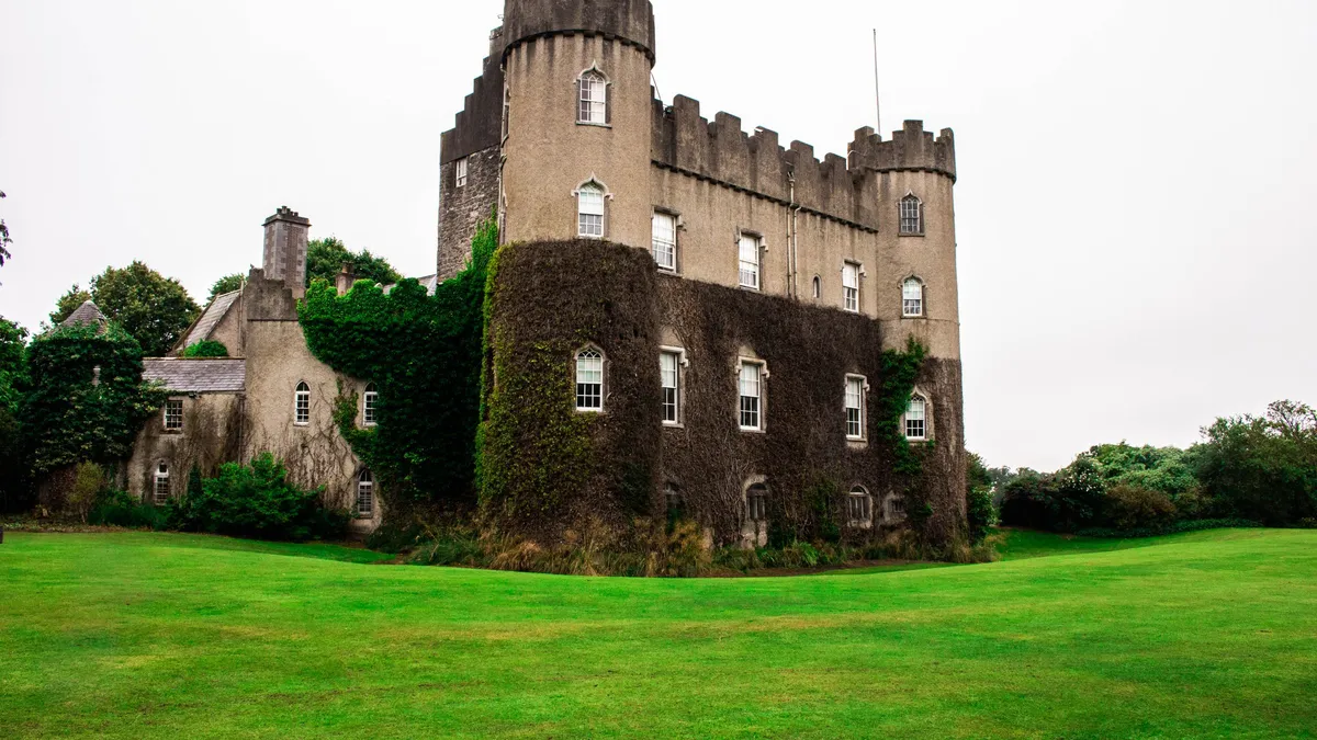 Malahide Castle behind its lawns with ivy on the walls