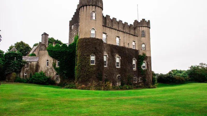 Malahide Castle behind its lawns with ivy on the walls