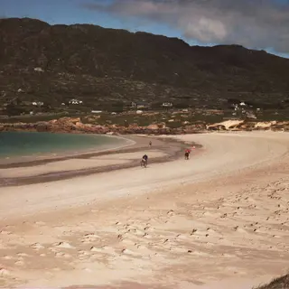 The pale curved strand at Dog's Bay with the hills of Connemara behind it