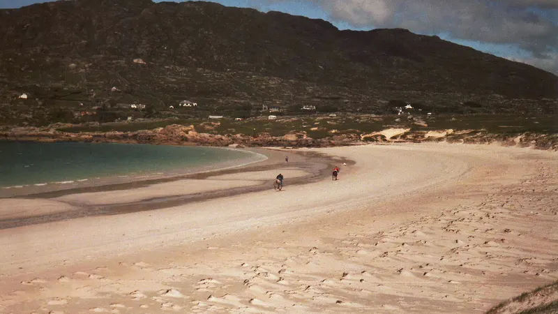 The pale curved strand at Dog's Bay with the hills of Connemara behind it
