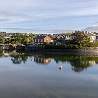 Waterfront houses reflected in the calm water at Kinsale