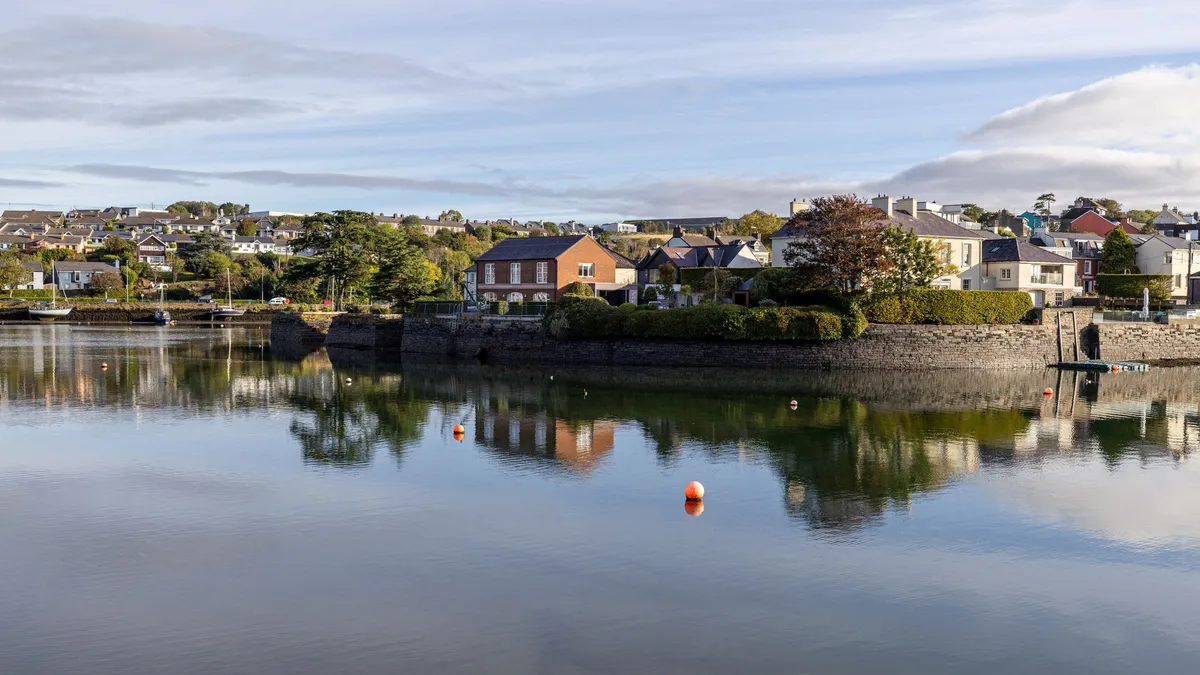 Waterfront houses reflected in the calm water at Kinsale