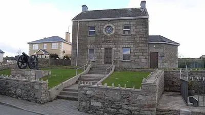 The stone Memorial Hall at Ballinamuck with a cannon on the grass beside it