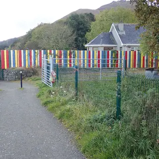 A brightly striped fence along the Carlingford Greenway where the path passes a school