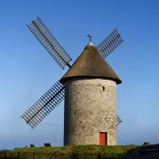 A stone windmill tower at Skerries under a blue sky