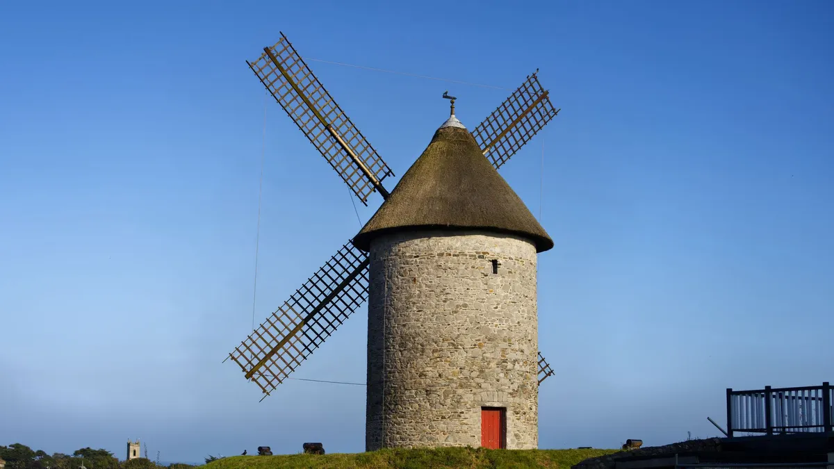 A stone windmill tower at Skerries under a blue sky