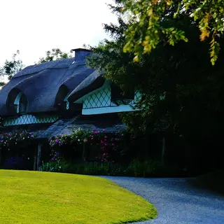 The curved thatched roof and veranda of the Swiss Cottage at Cahir