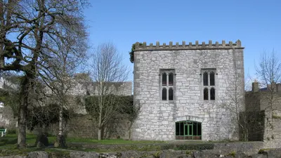 The stone hall and castle buildings at Newcastle West behind their lawn