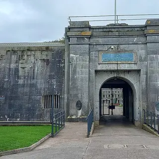 The arched stone gateway into Fort Mitchel on Spike Island, with a cannon on the grass beside it