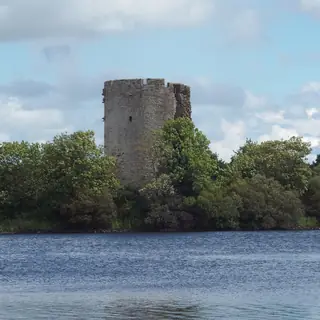 The round keep of Clogh Oughter Castle on its wooded island in Lough Oughter
