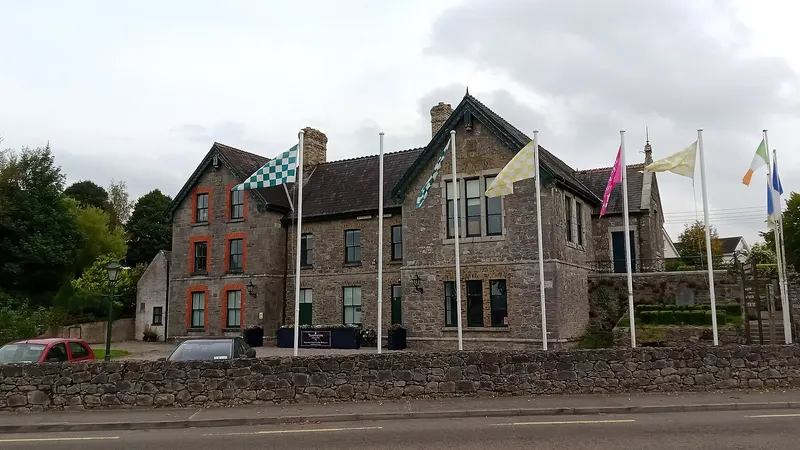 The stone front of Abbeyleix Heritage House with flags outside it