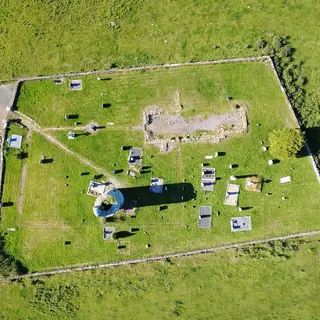 The walled graveyard at Old Kilcullen seen from above with the stump of the round tower inside it