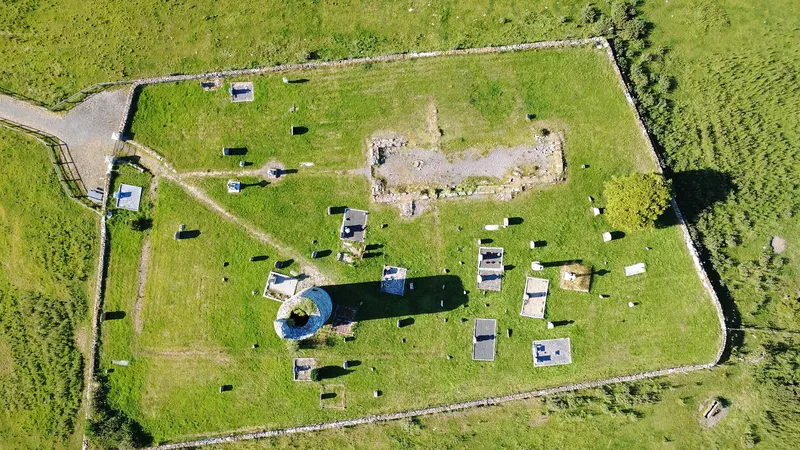 The walled graveyard at Old Kilcullen seen from above with the stump of the round tower inside it