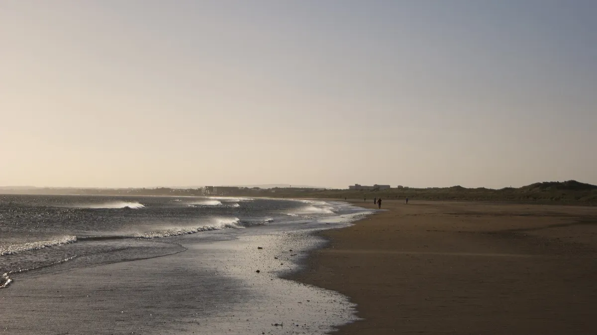 The long flat beach at Laytown at dusk with the tide out
